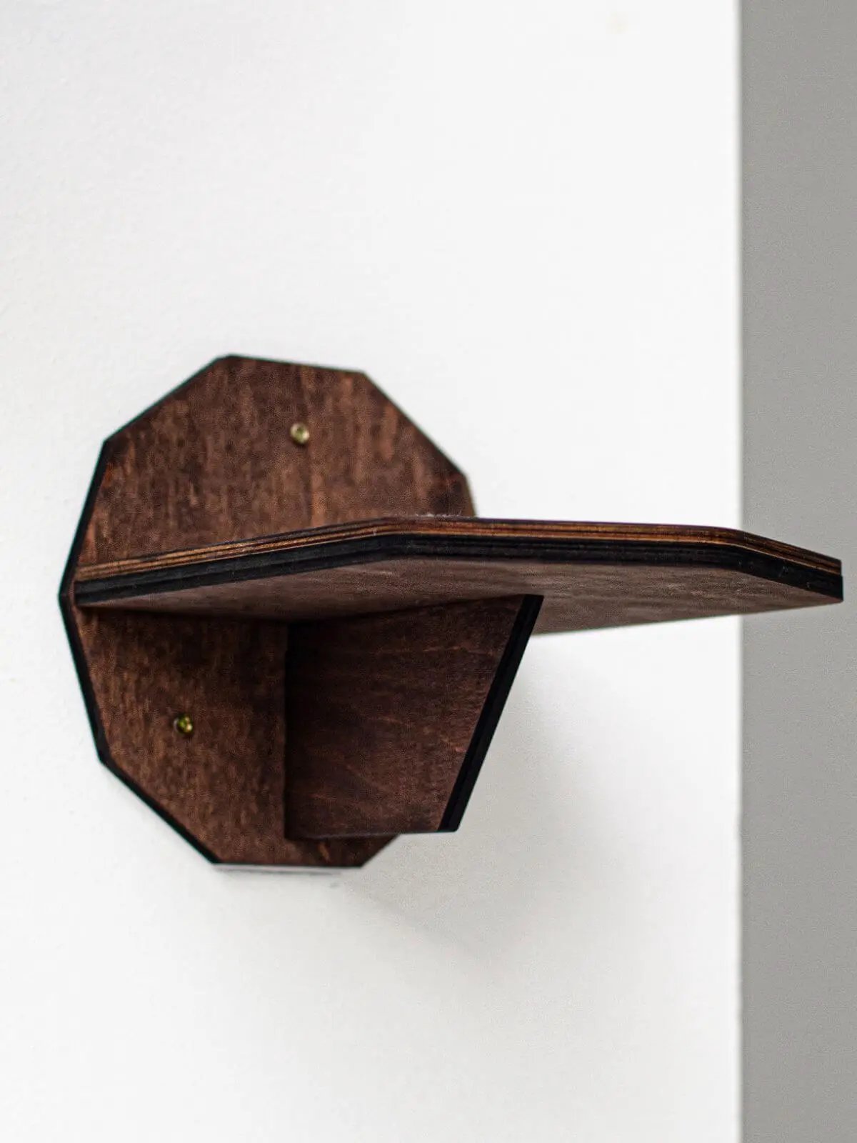Wall-mounted wooden cat steps, brown stained wood with a single protruding step.